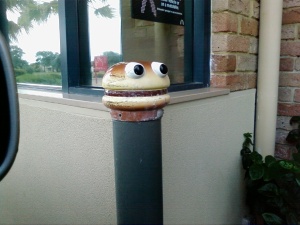Macca's burger monster sculpture on drive-thru bollard